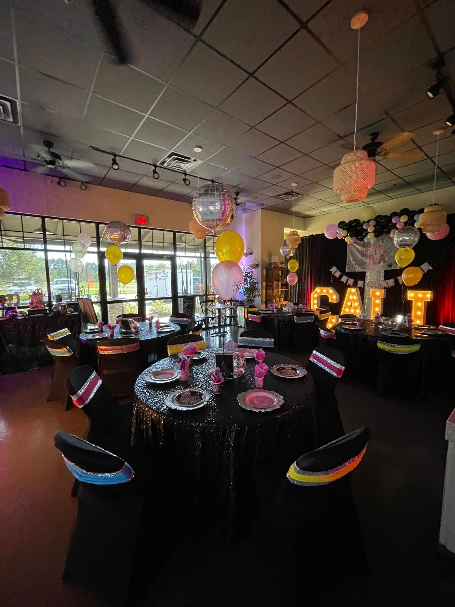A large room with tables and chairs set up for a party.