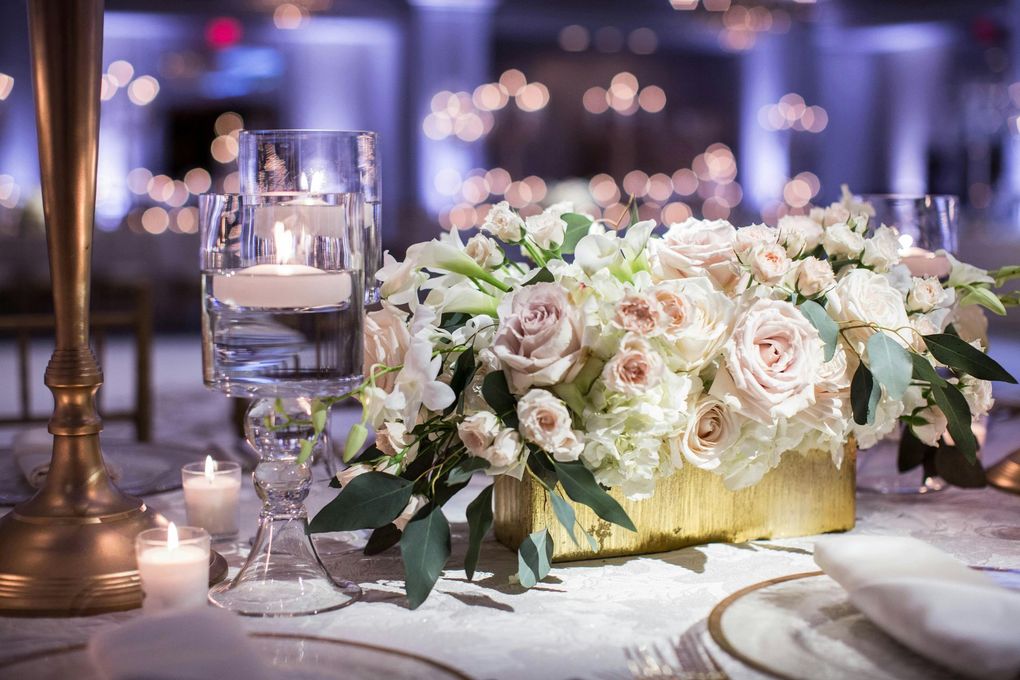 A table with a vase of flowers and candles on it.