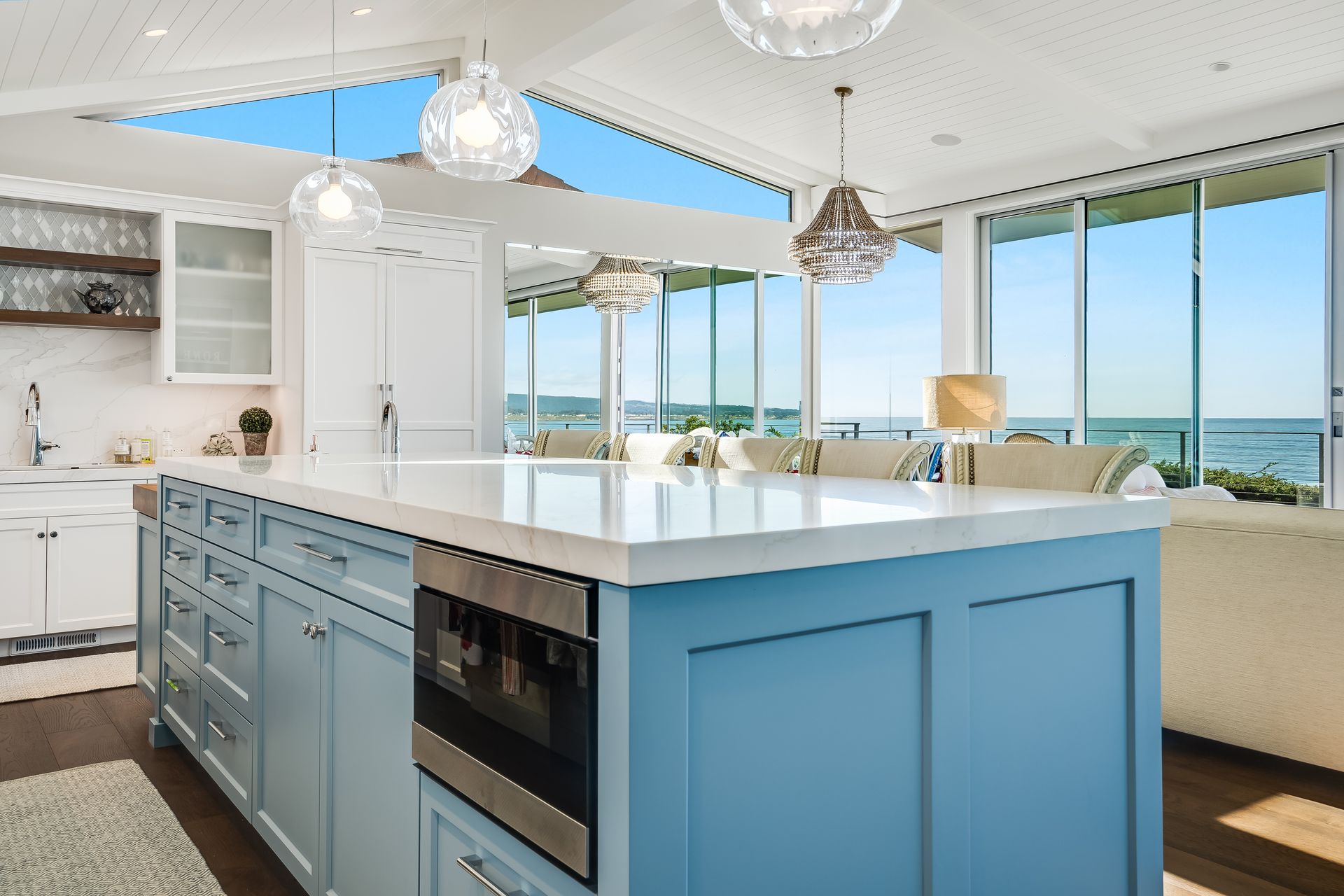 Bright modern kitchen with blue island and ocean-view windows