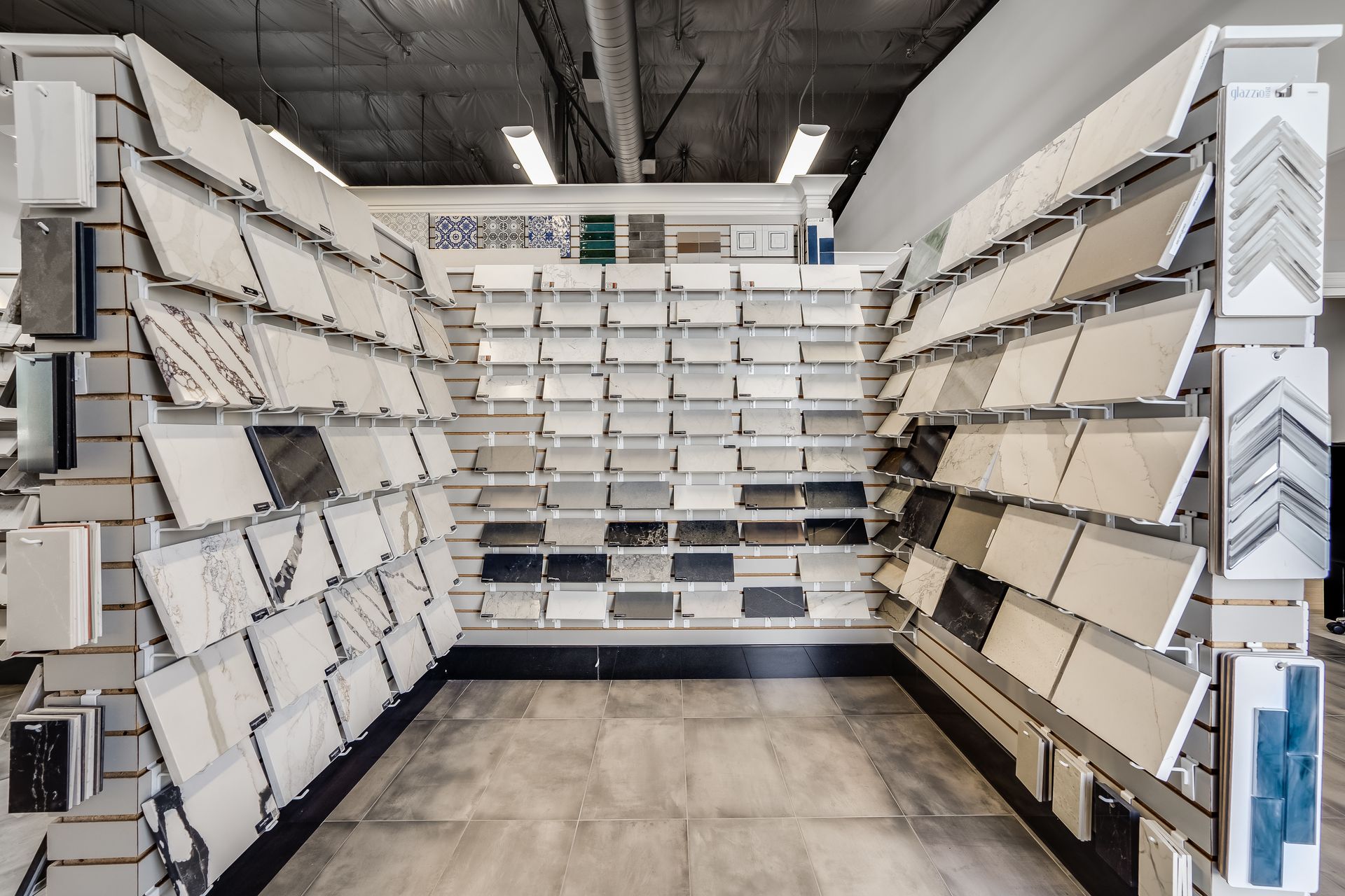 Wall of white and gray display shelves in a tile or flooring showroom