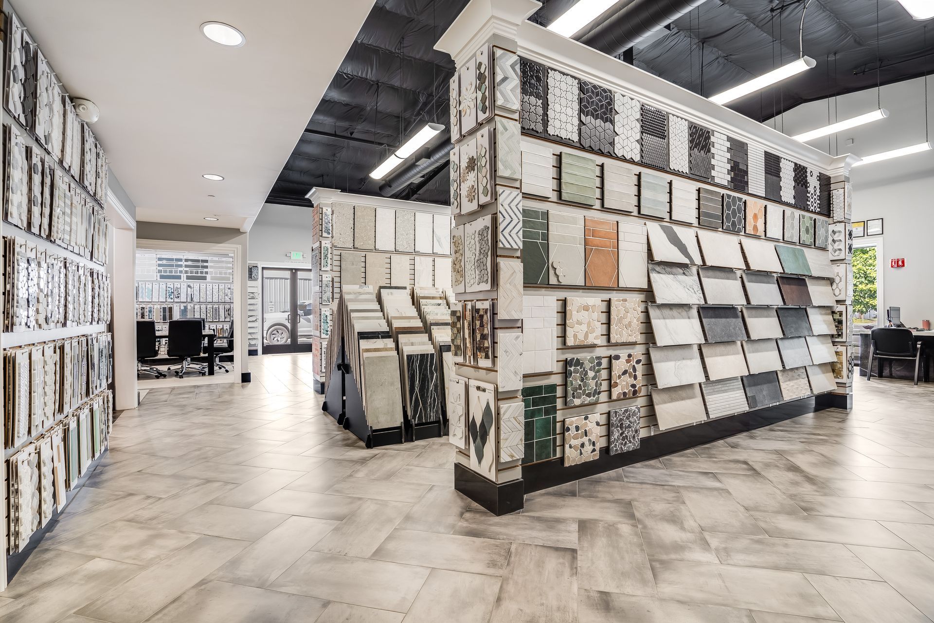 Modern tile showroom with display walls of patterned tiles and light wood flooring