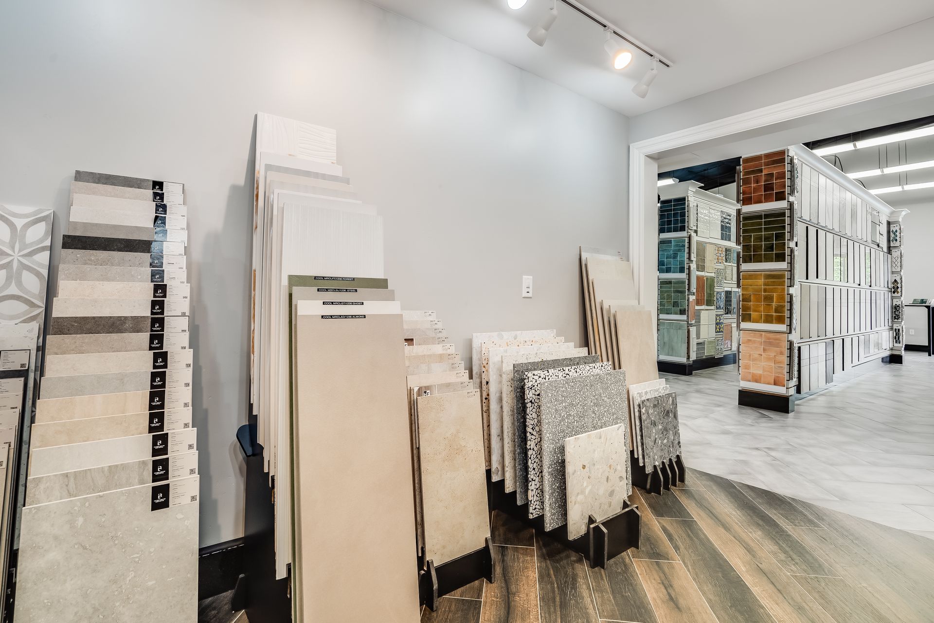 Tile showroom with stacked floor and wall samples in a bright, modern display room