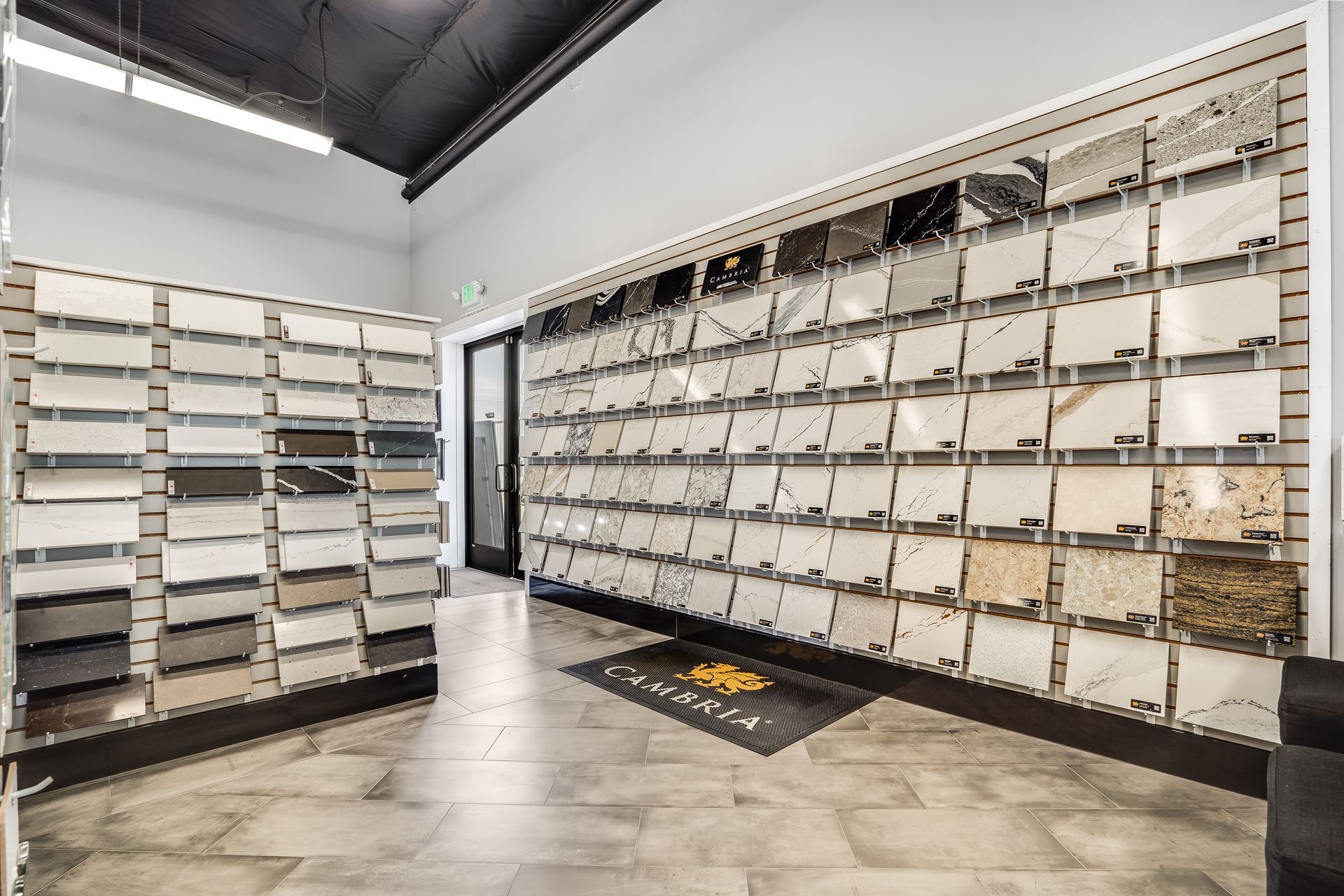 Modern room with white wall-mounted mailboxes and a gray tiled floor, viewed from the corner.