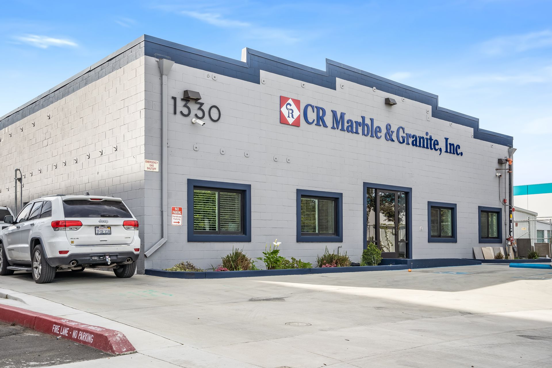 Exterior of CR Marble & Granite, Inc. building with parked SUV and gray facade