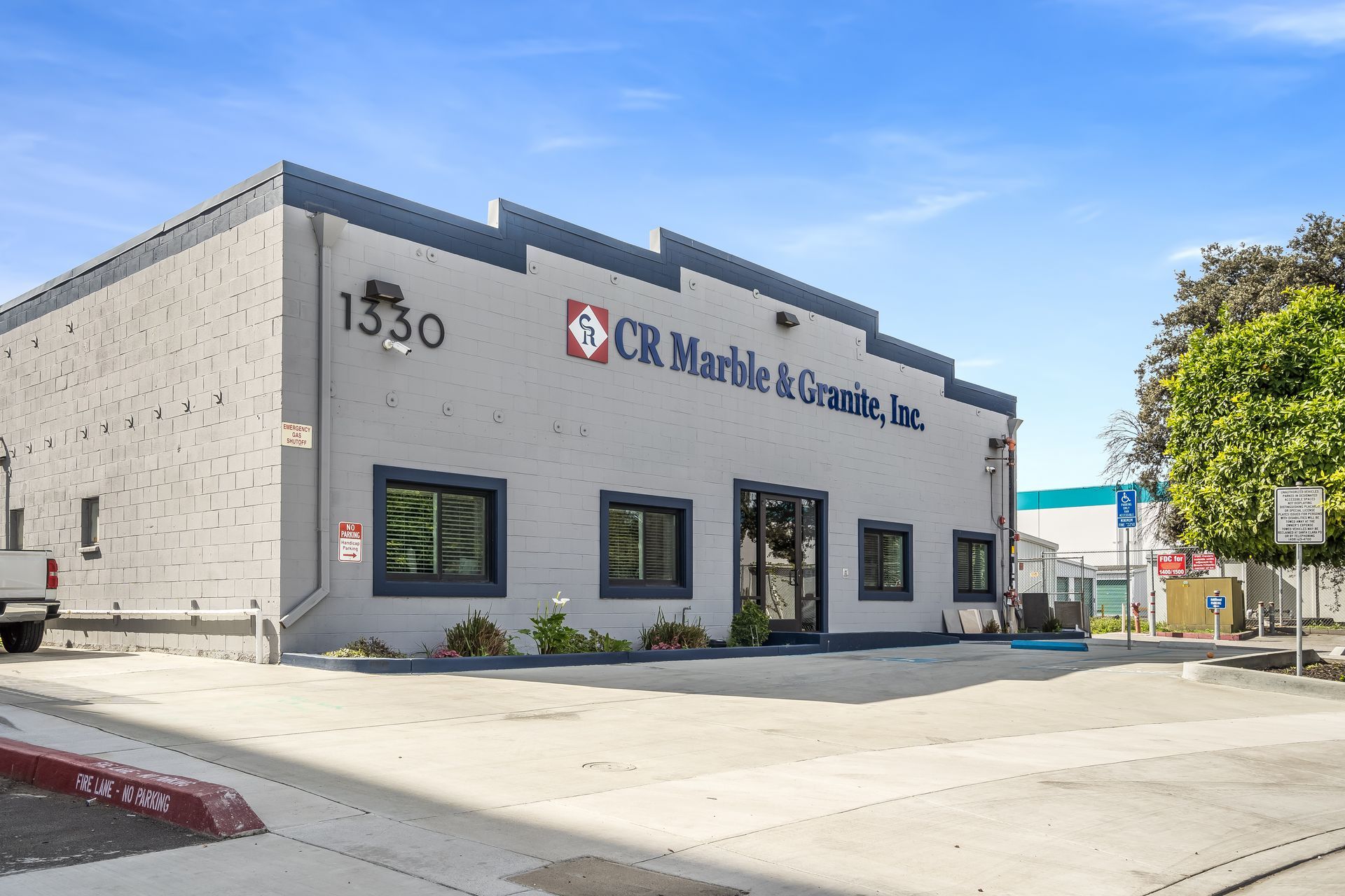 Exterior of CR Martin & Associates, a gray commercial building with black windows and red trim