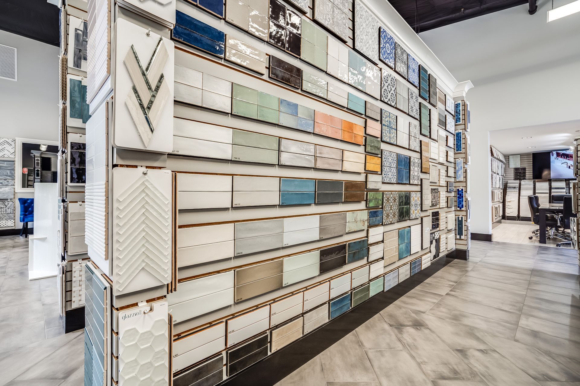Tile showroom wall with rows of sample panels in neutral colors and patterns