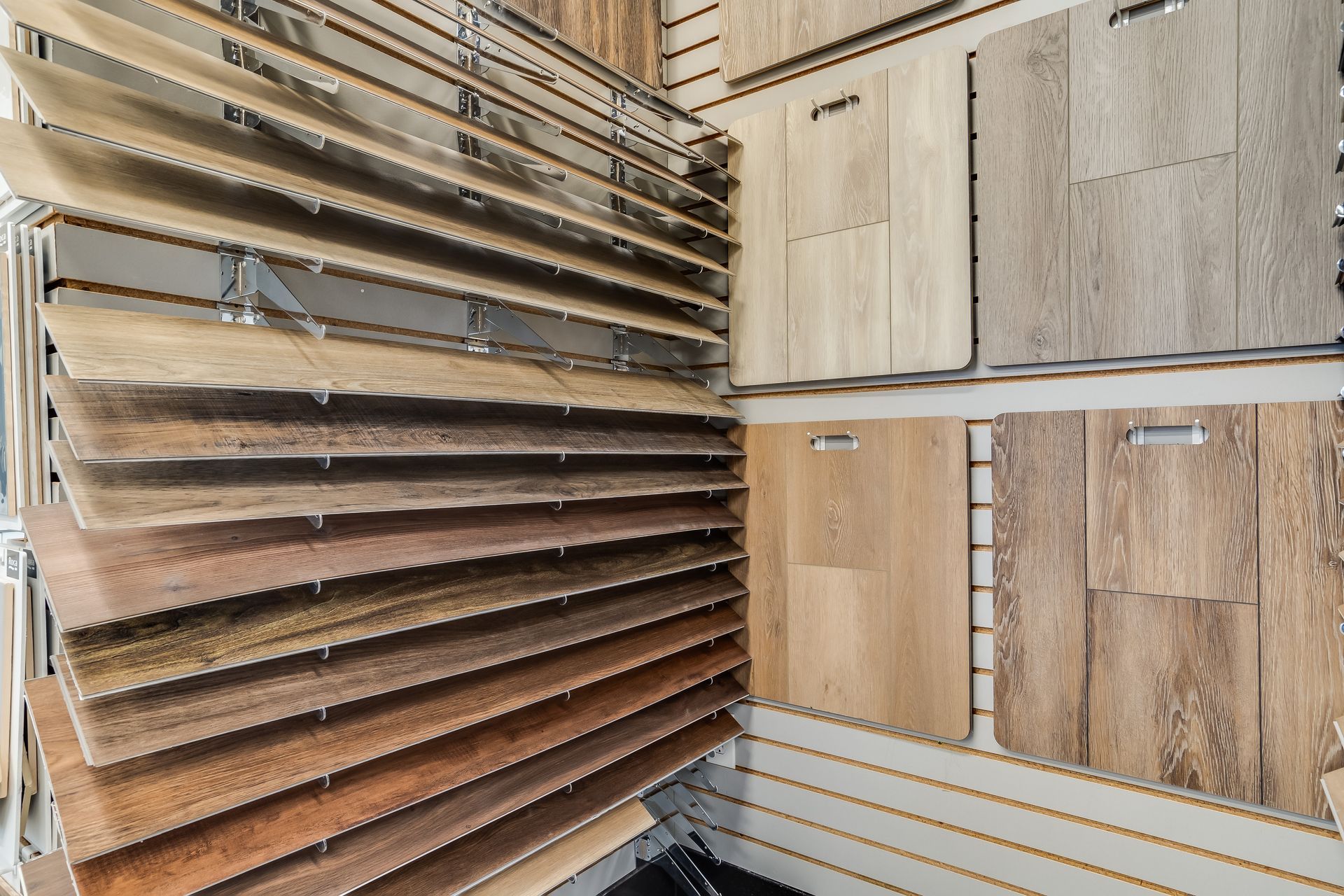 Wood flooring and tile samples displayed in a showroom wall rack