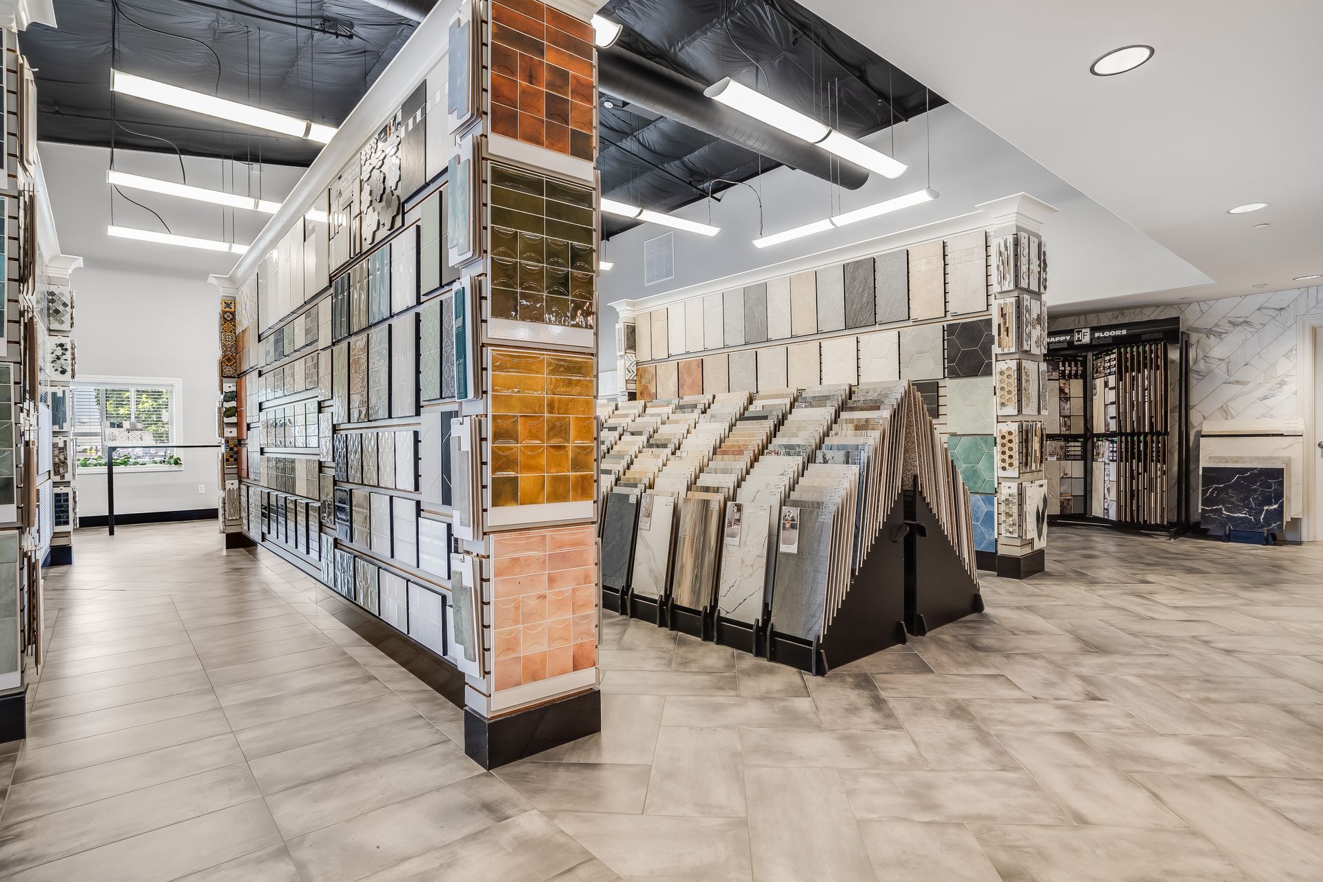 Modern flooring showroom with tile displays and sample racks in a bright open interior