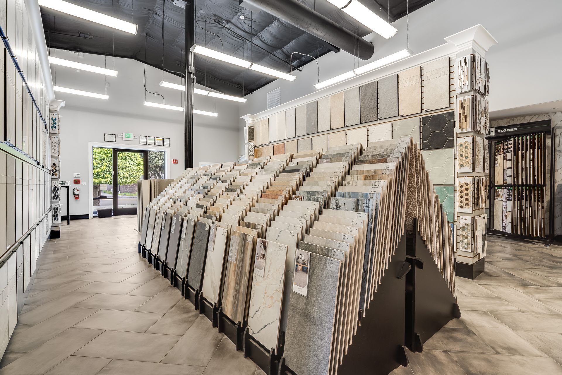 Interior of a flooring showroom with rows of sample tiles and bright overhead lights