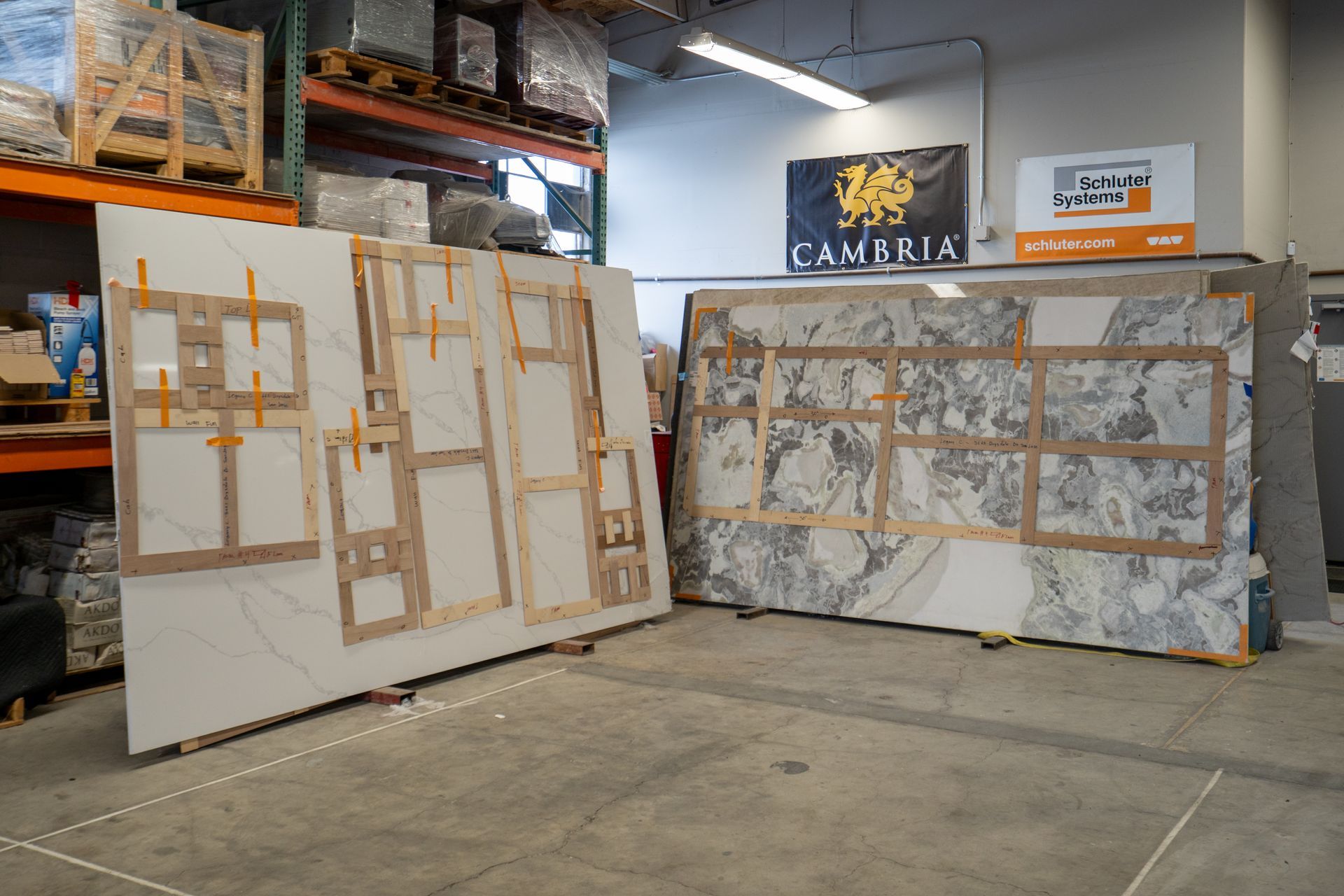 Two large painted panels leaning in an industrial workshop under a CAMARIA sign