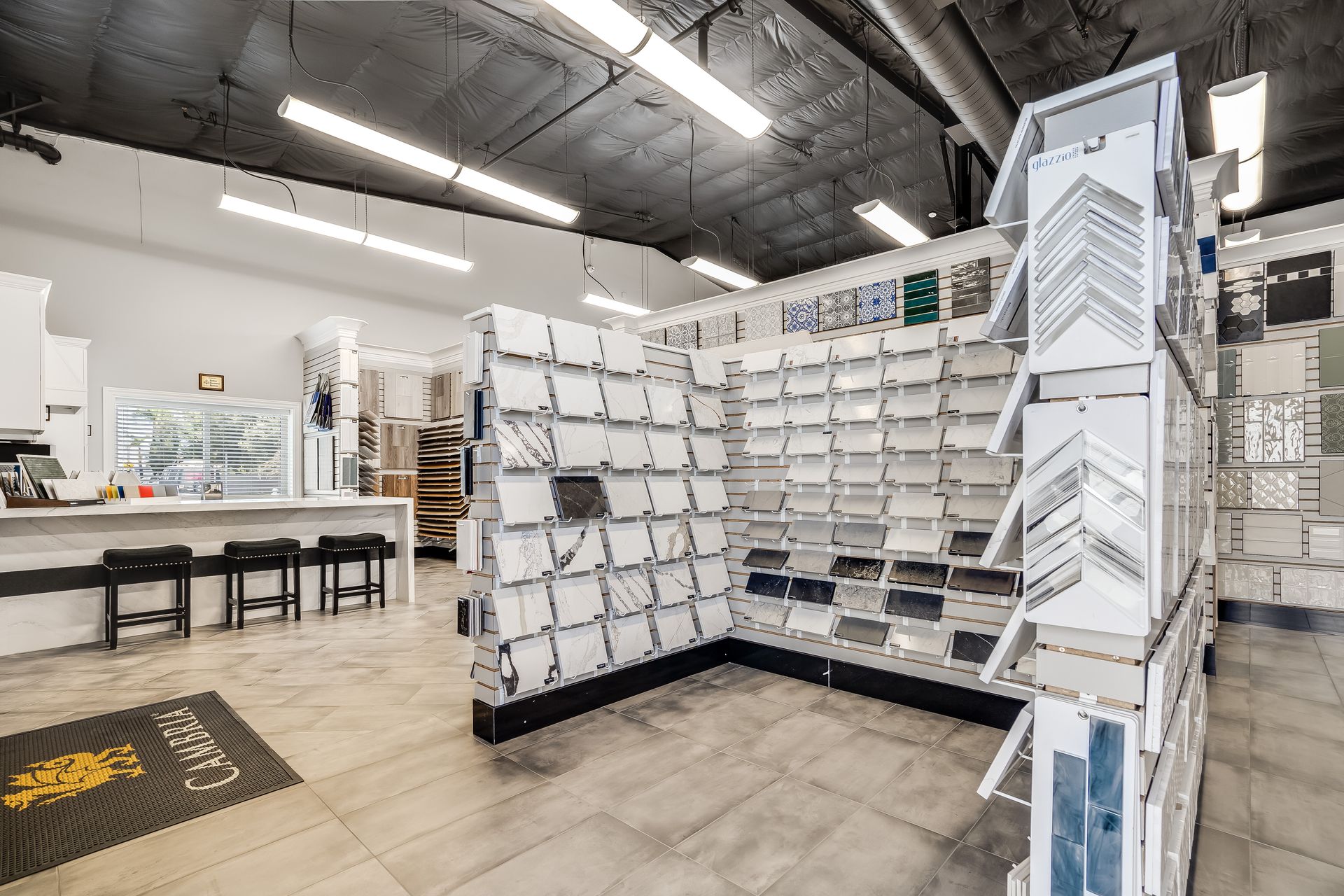 Modern retail store interior with racks of white cards, displays, and tables under bright lights