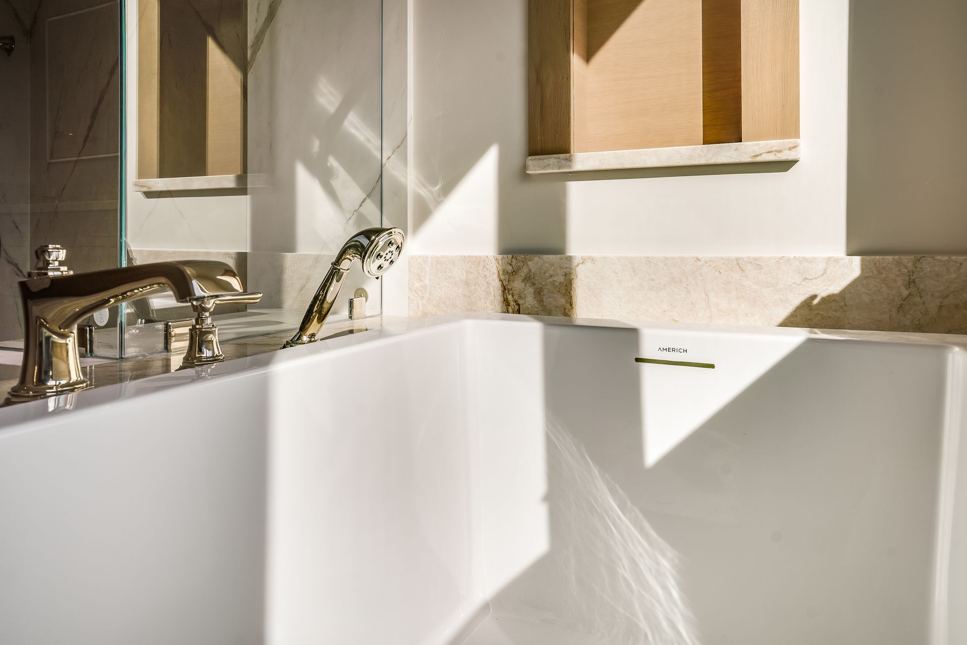 Sunlit bathroom with a white bathtub, chrome faucet, and two windows above the tub