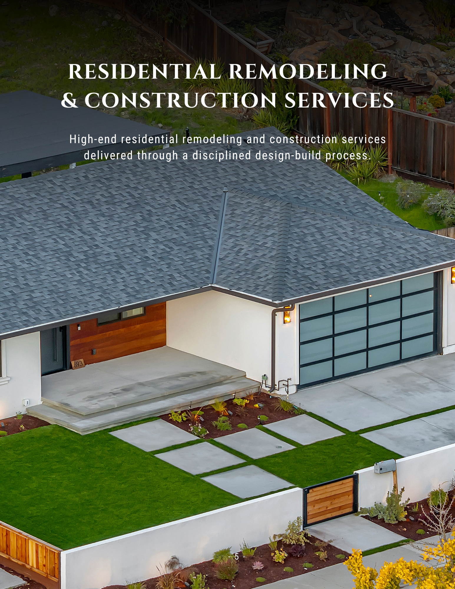 Modern house exterior with a gray roof and lawn, promoting residential remodeling and construction services