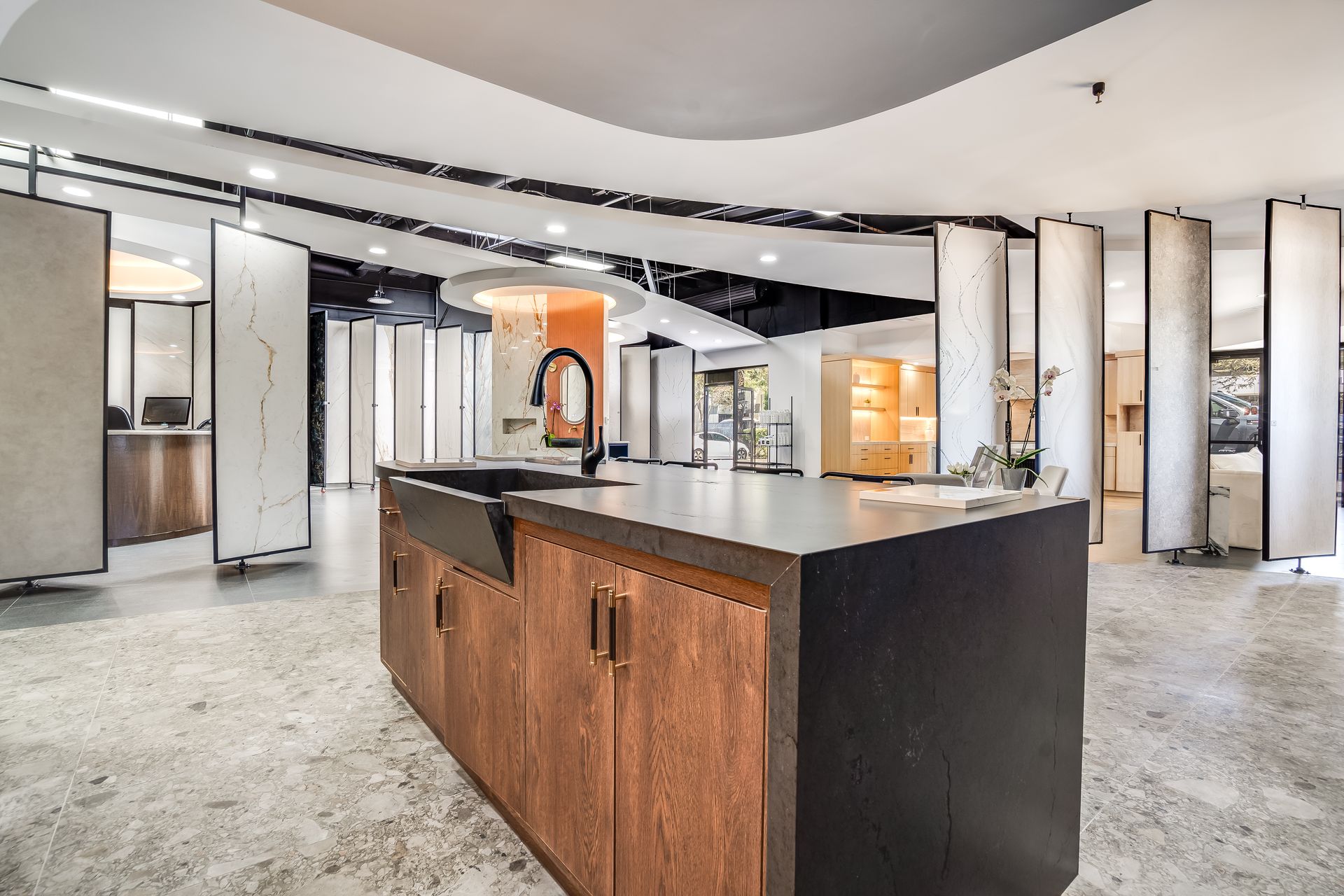 Modern kitchen showroom with a central island and multiple cabinet displays