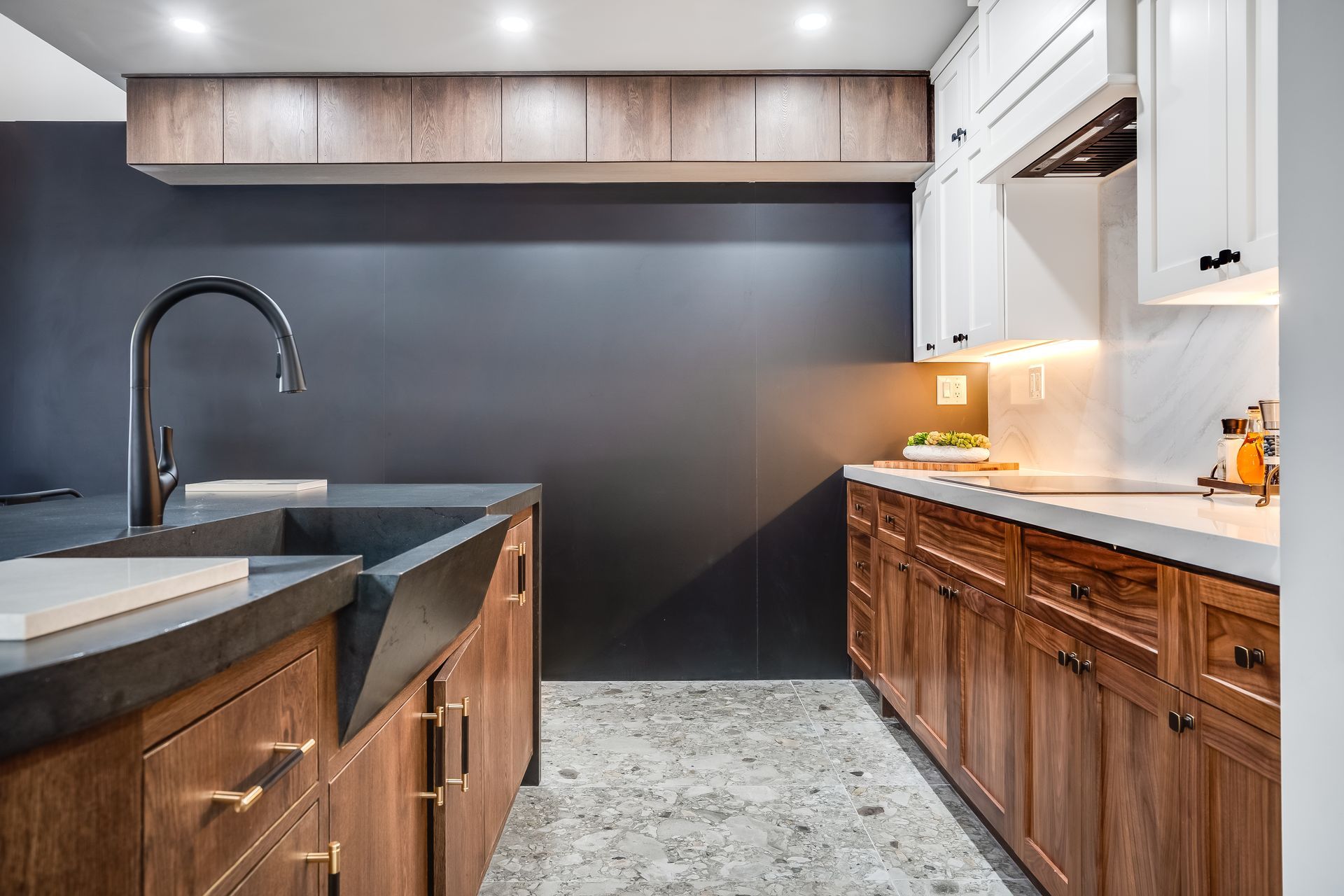 Modern kitchen with wood cabinets, dark countertops, and a black backsplash