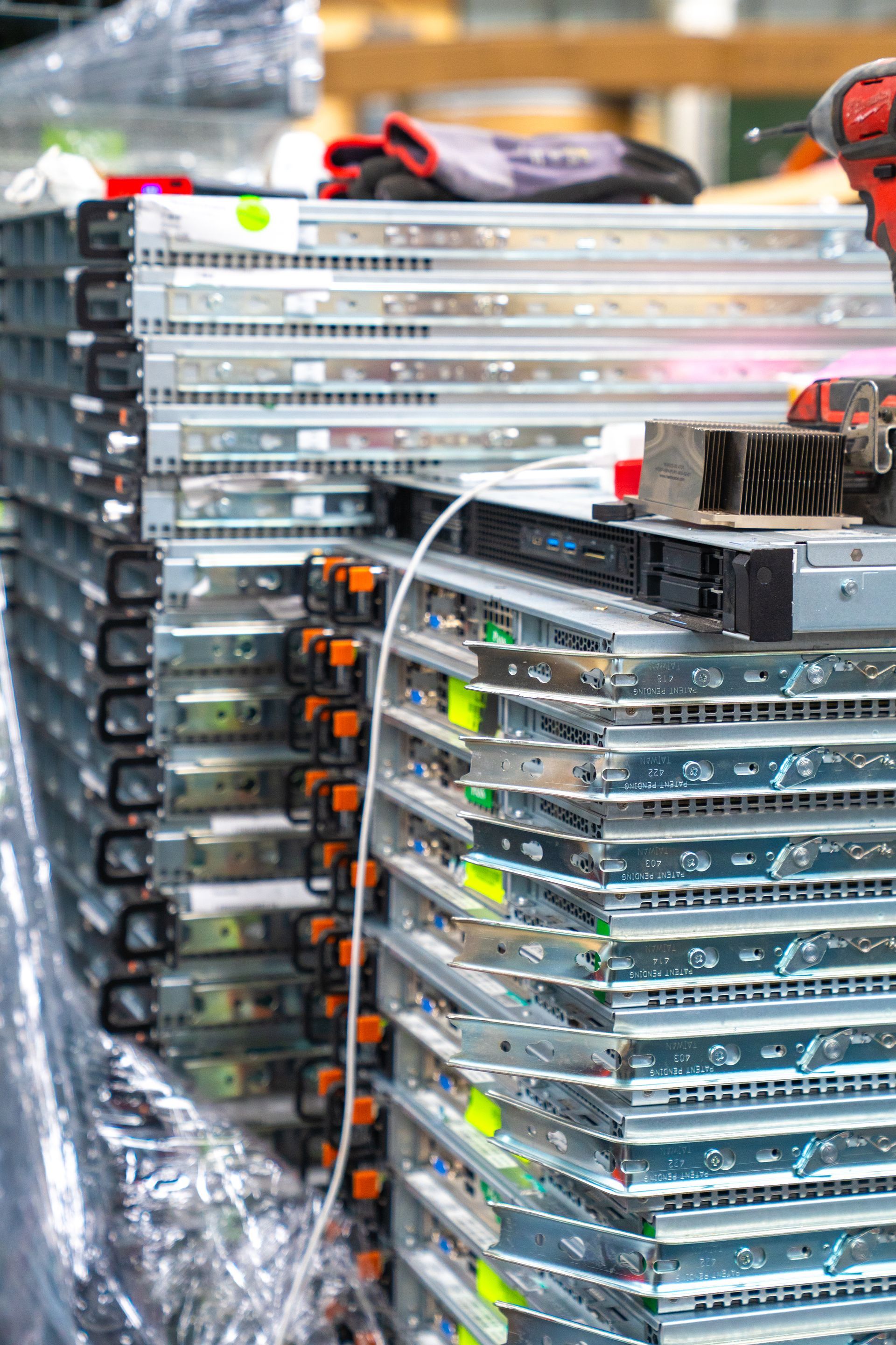 Stack of server racks, metallic silver with visible orange and green components.