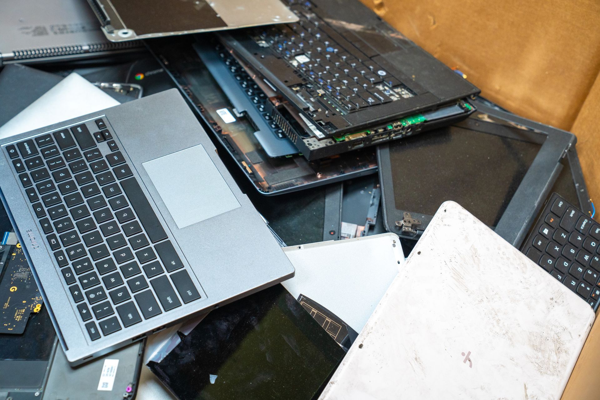 Pile of dismantled laptops and screens, likely for recycling.