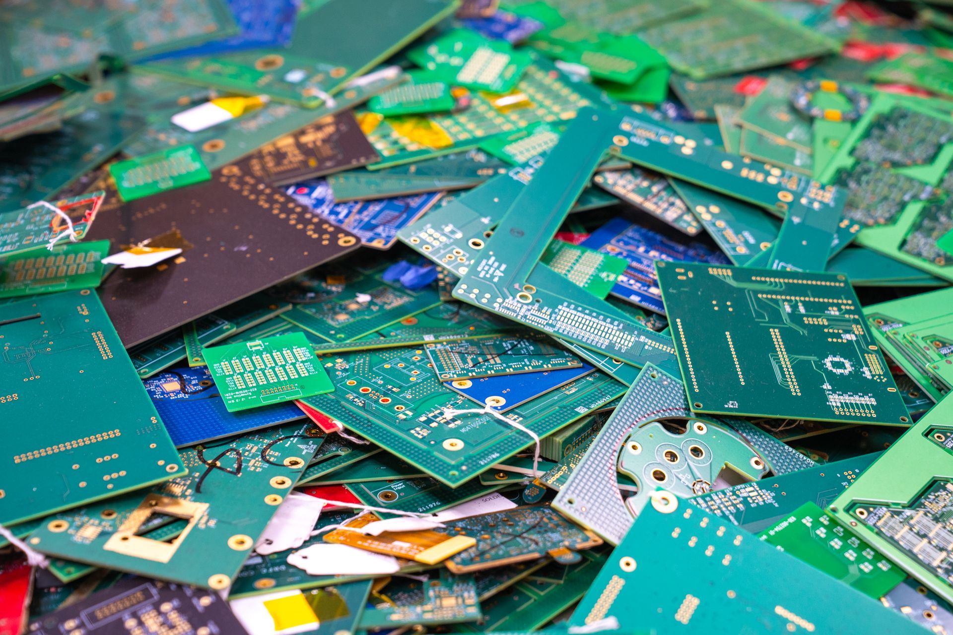 Pile of discarded circuit boards in various colors.