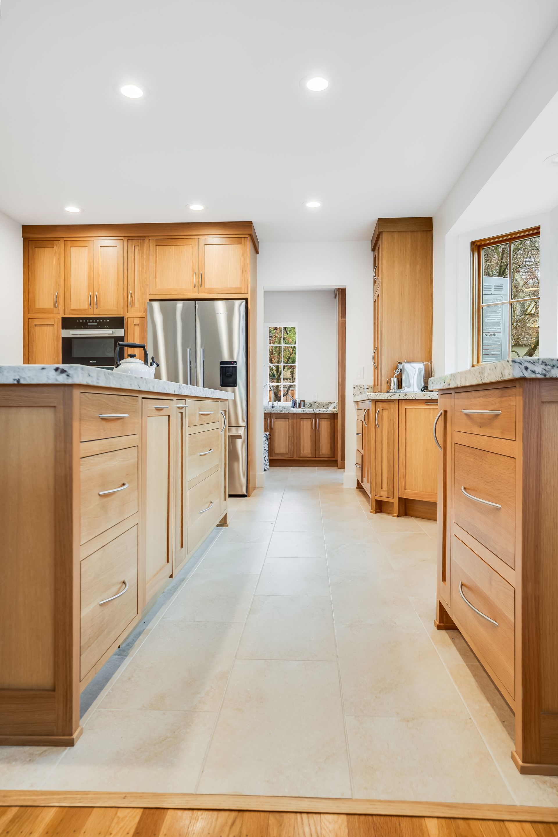 Bright kitchen with light wood cabinets, stainless appliances, and a large central island