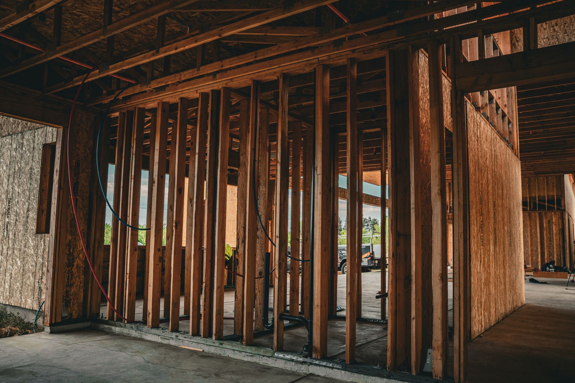 Partially framed wooden building interior with exposed studs and beams under construction