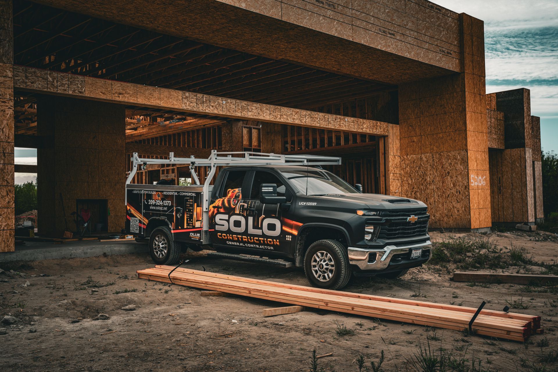 Black Solo pickup truck parked under a brick garage with wooden planks in front