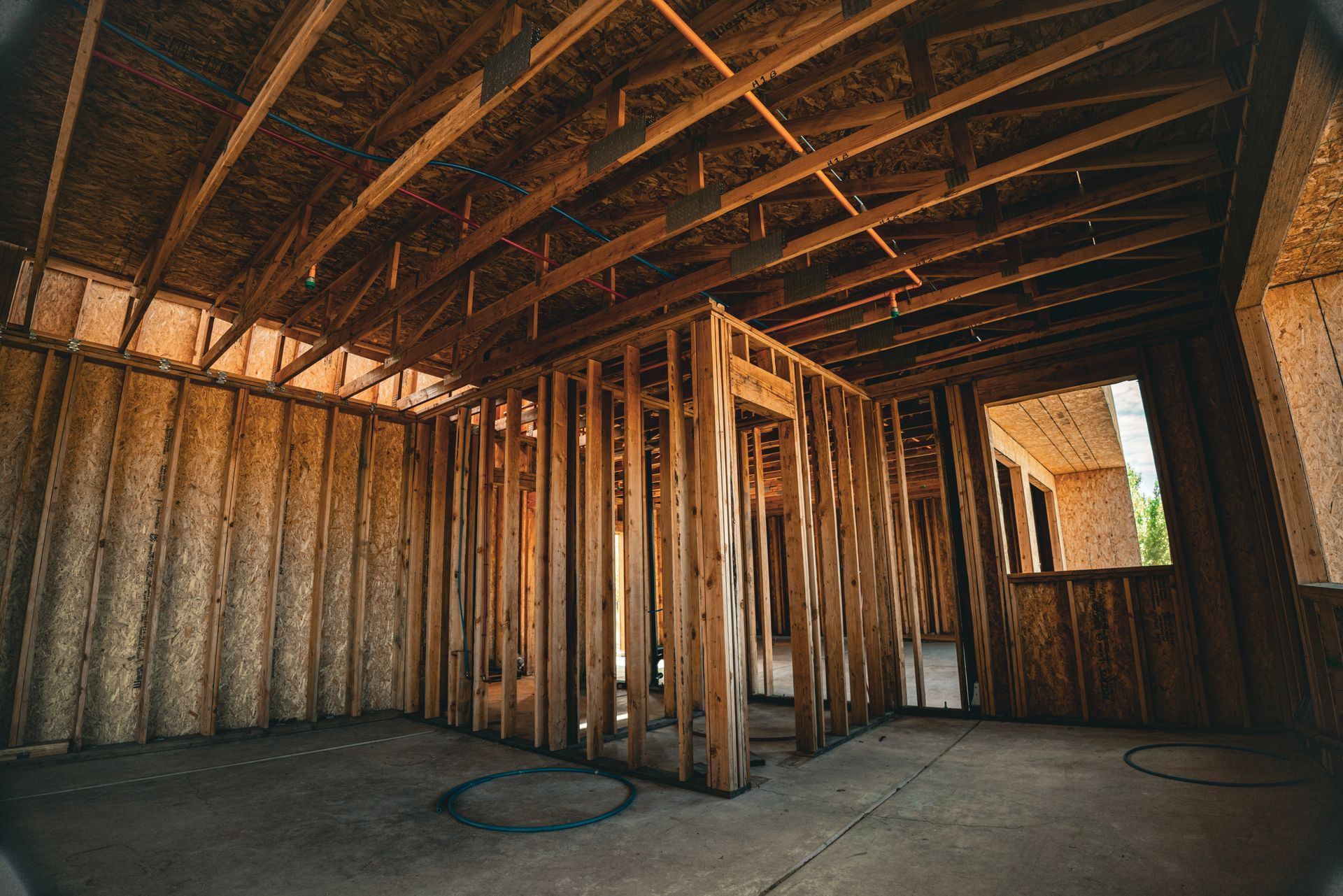 Interior of an unfinished wooden house framing, with exposed beams and insulation under construction
