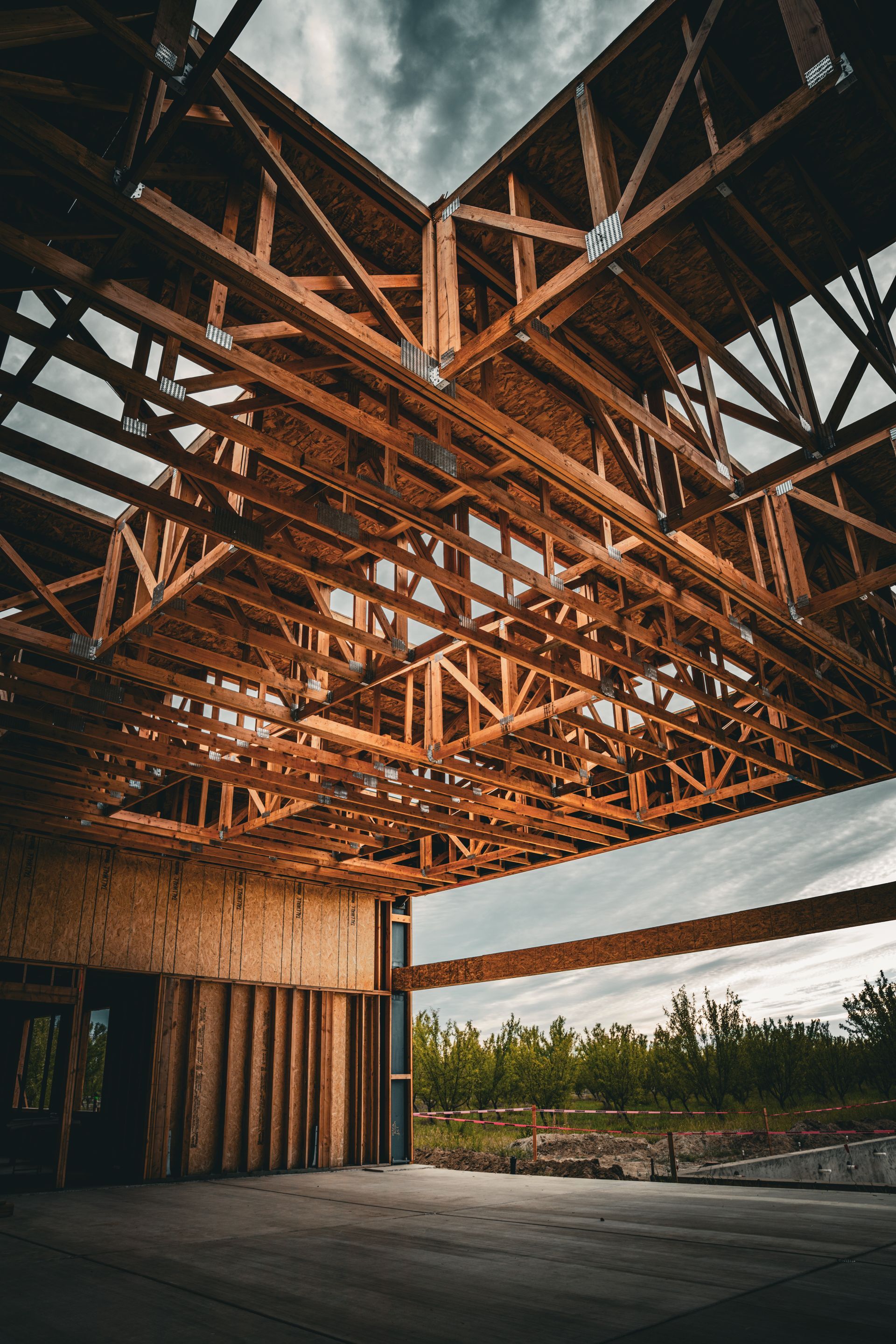 Partially built wooden structure with exposed beams and open walls, viewed from inside the unfinished space.