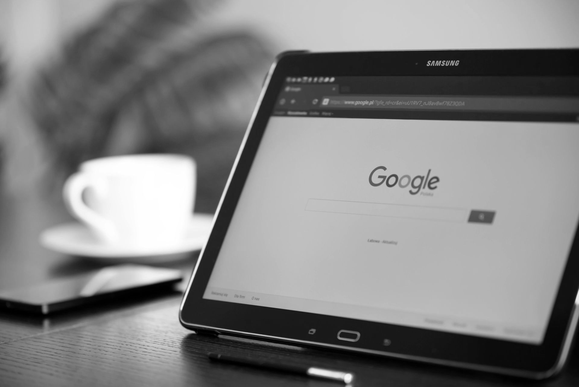A black and white photo of a tablet with the word google on the screen.