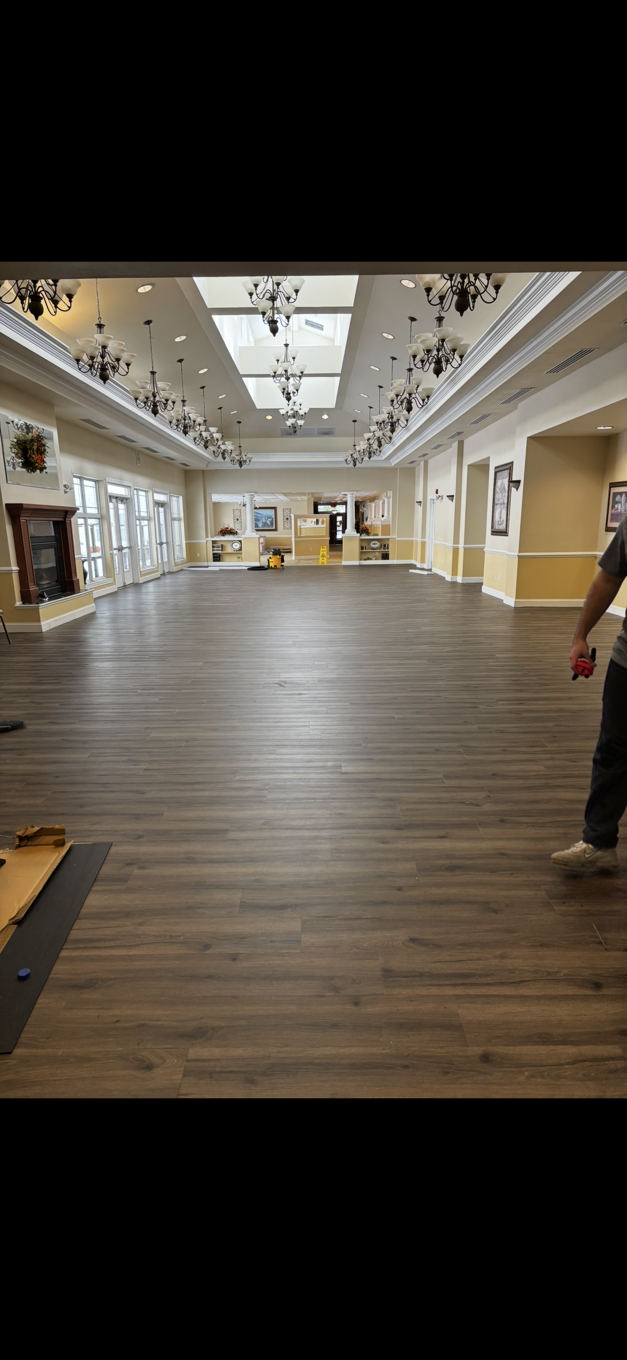 Various wood flooring samples in different shades, with a matching floor in the background.