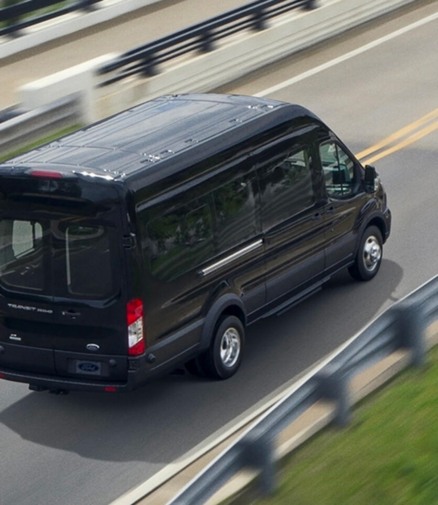 Passengers boarding an airport shuttle bus at a terminal curbside lane