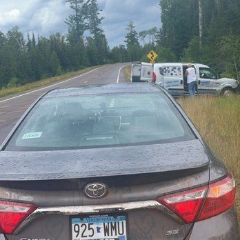 Car on the side of the road. Glen making a key for me in the distance.