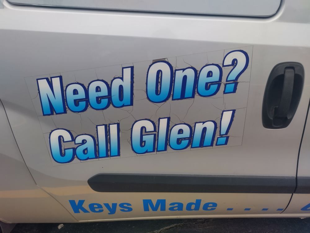 Blue lettering on a silver van door reads, “Need One? Call Glen!” with “Keys Made” below.