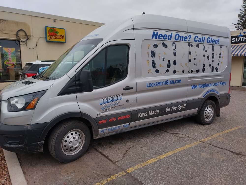 Silver service van parked outside a store, with “Need One? Call Glen” and Locke & Load signage.
