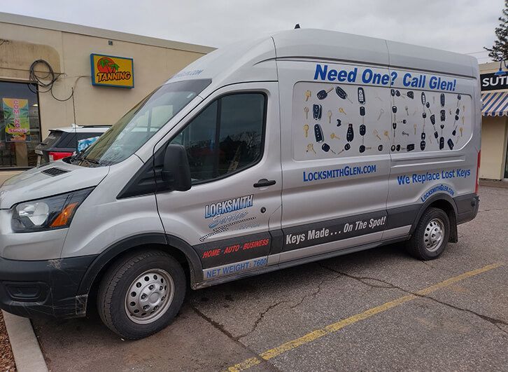 White service van with phone number and “Need One? Call Gail” parked outside a store