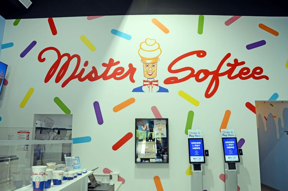 Mister Softee ice cream shop interior with colorful wall mural and self-order kiosks