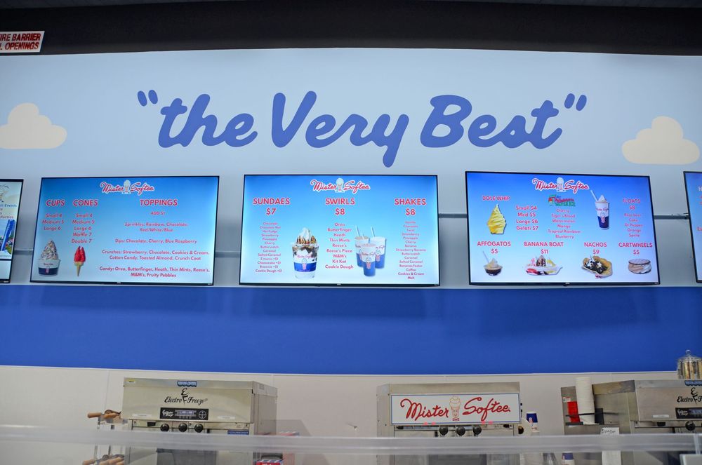 Store wall menu with "The Very Best" sign and three blue menu boards