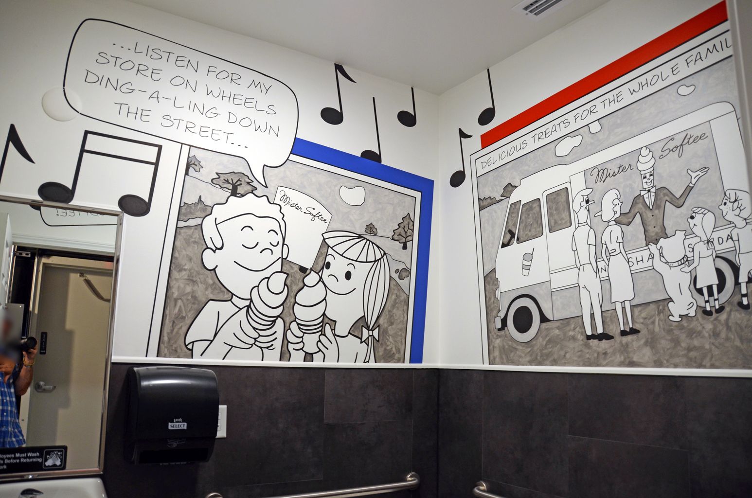 Black-and-white mural wall with musical notes and framed art above a black bench in a modern interior