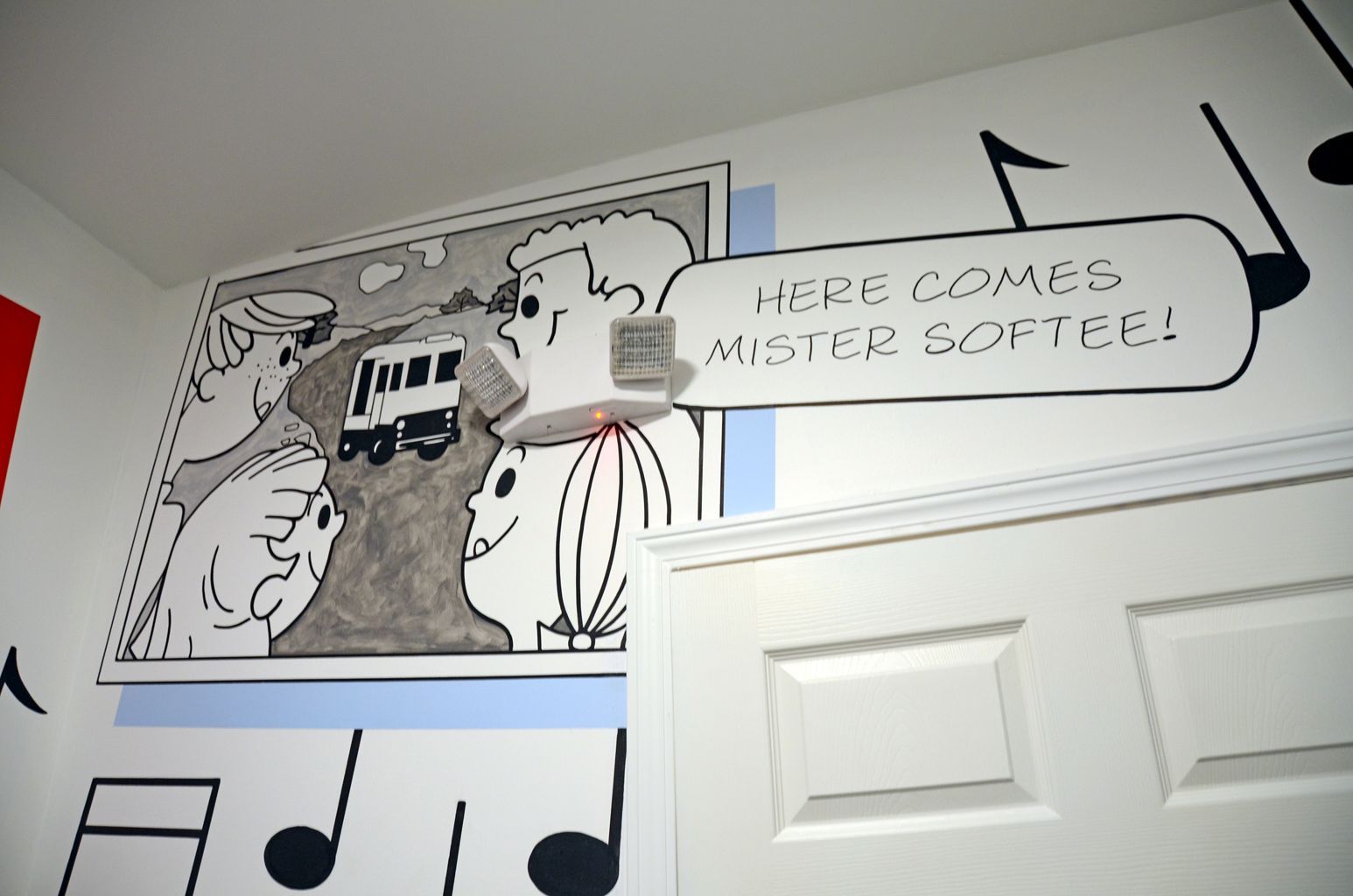 Wall mural with a cartoon train, hot air balloon, and speech bubble above a doorway
