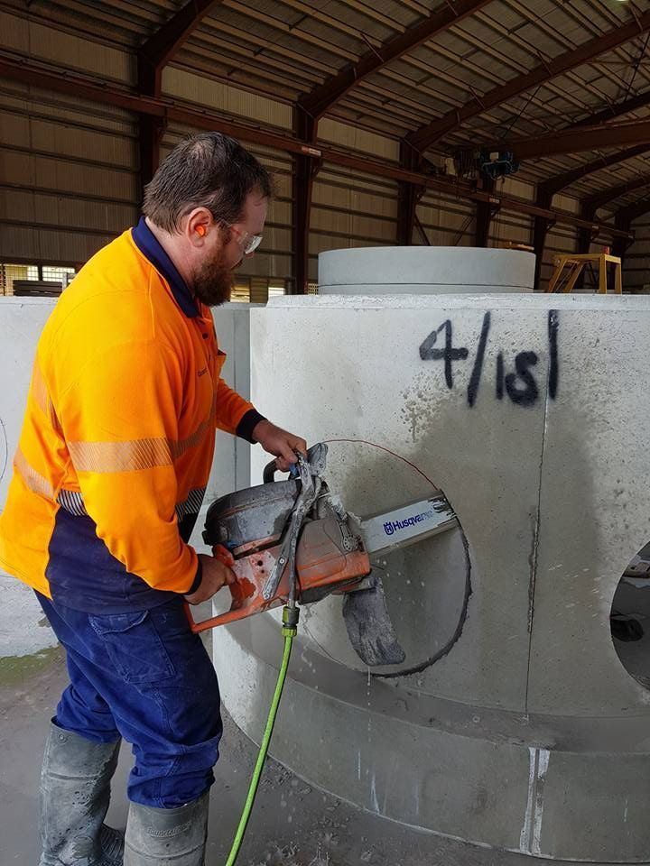 A Man is Cutting a Concrete Pipe With a Chainsaw — Di-Core Drilling and Cutting in Darwin, NT