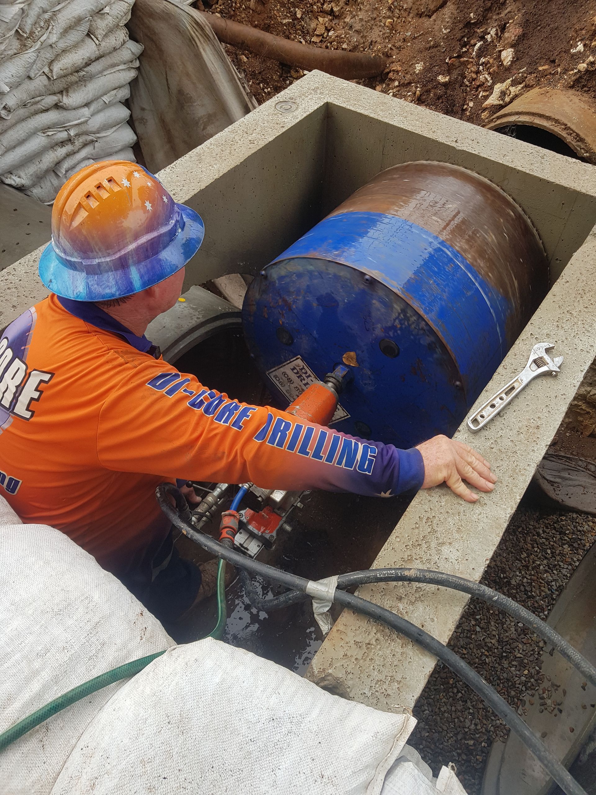 A Man is Standing Next to a Machine That is Cutting Concrete — Di-Core Drilling and Cutting in Darwin, NT