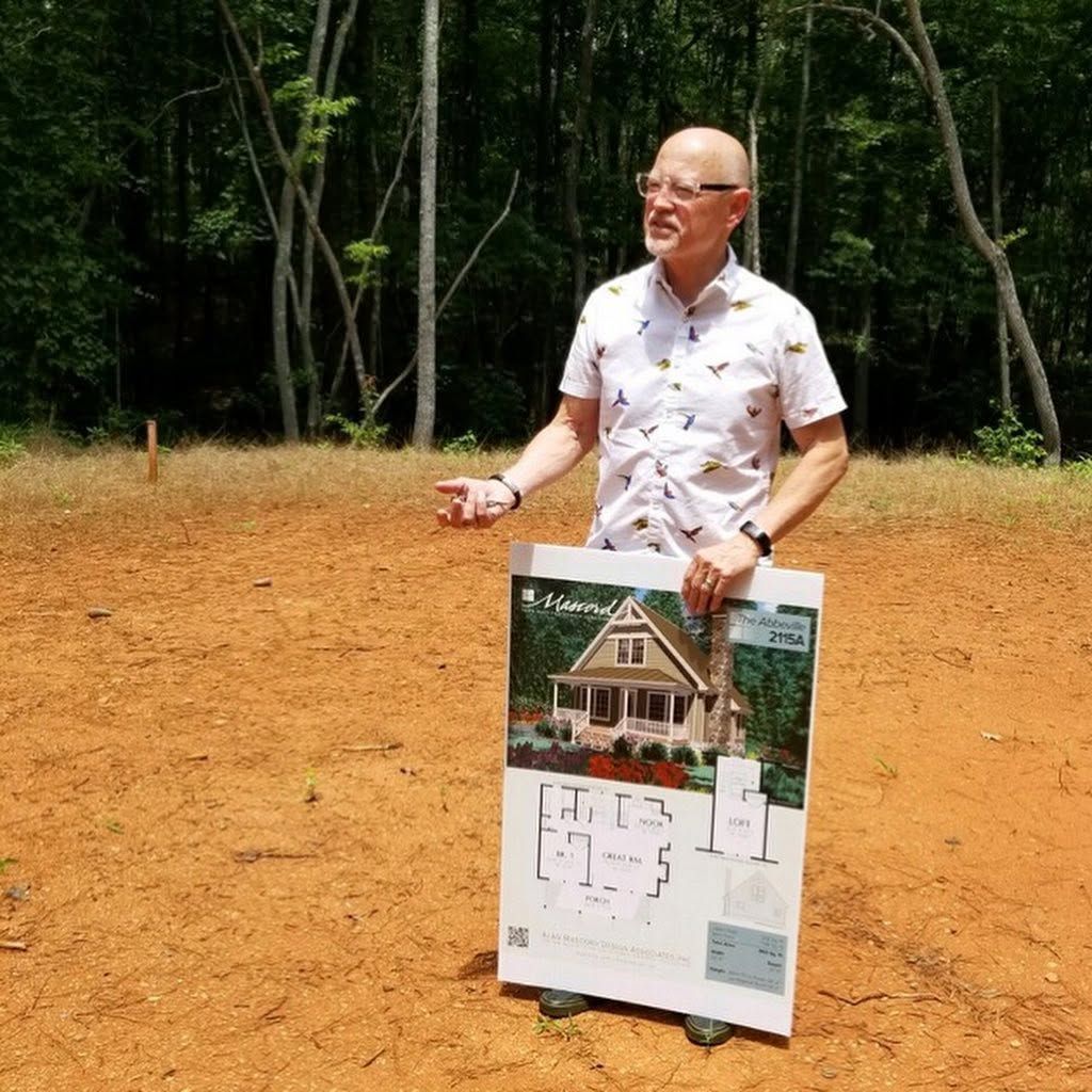 The founder sharing the early cottage plans on the Grace Valley property.