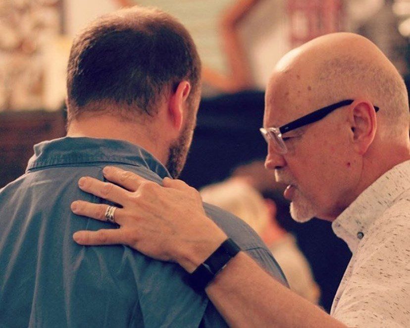 A pastor praying over another ministry leader