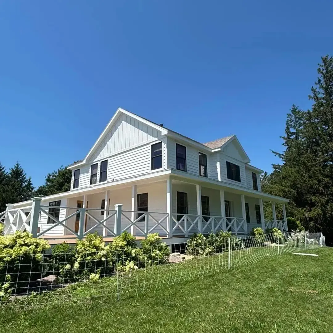Freshly painted white two-story home with wraparound porch in Rochester, Minnesota