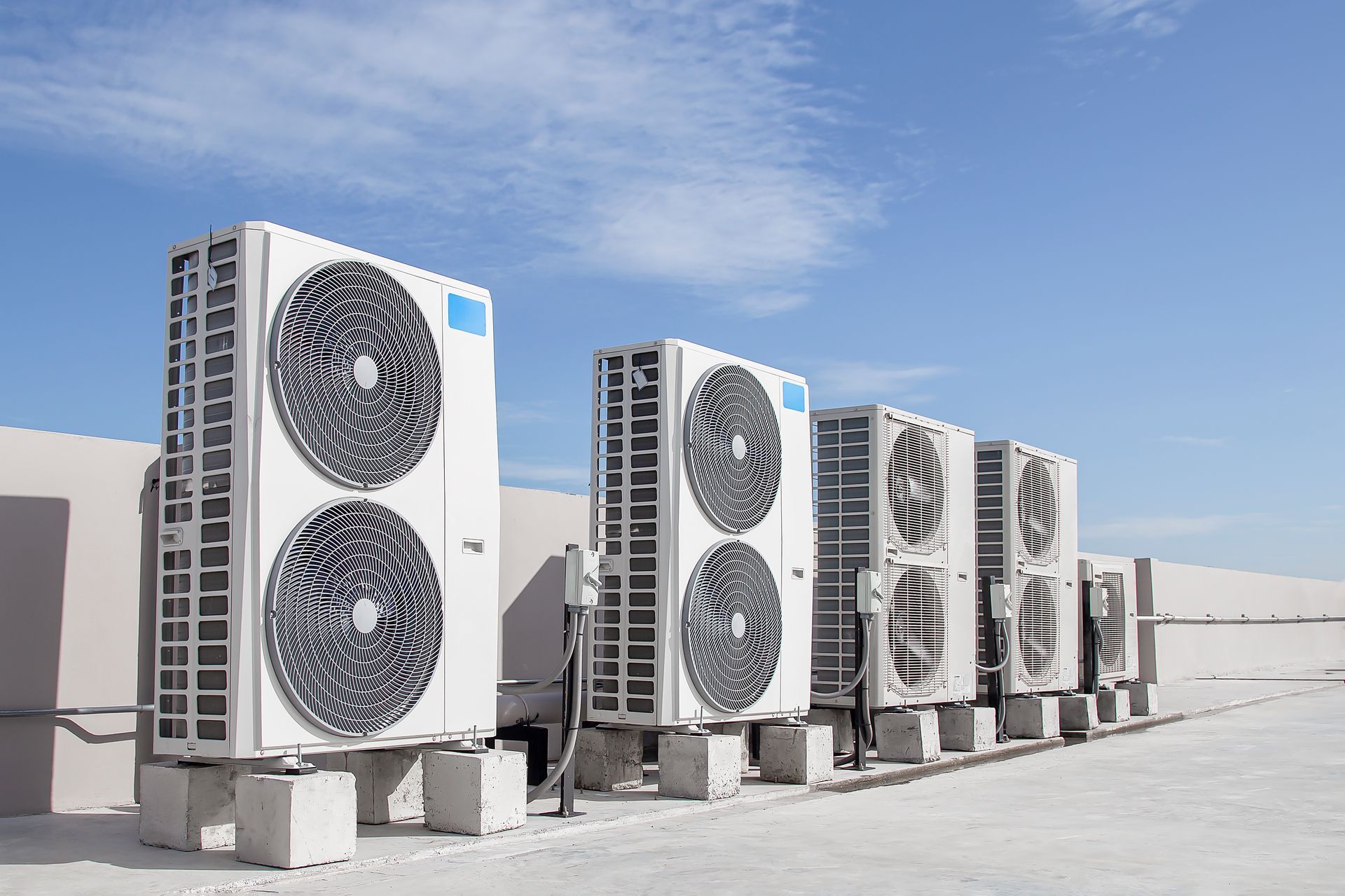 A row of air conditioners are sitting on top of a building.