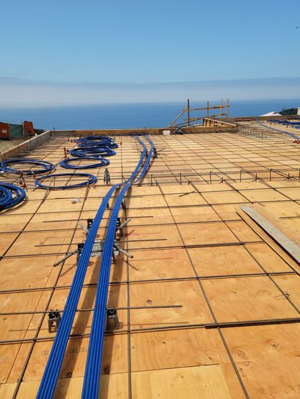 Construction platform with blue cables running across a wooden deck under a clear sky