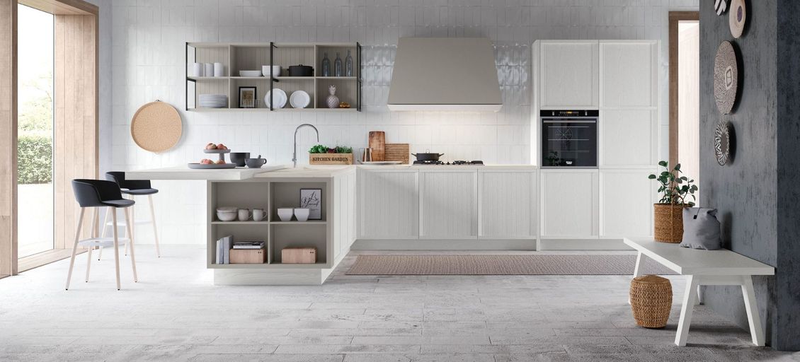 Una cucina con mobili bianchi e una panca al centro