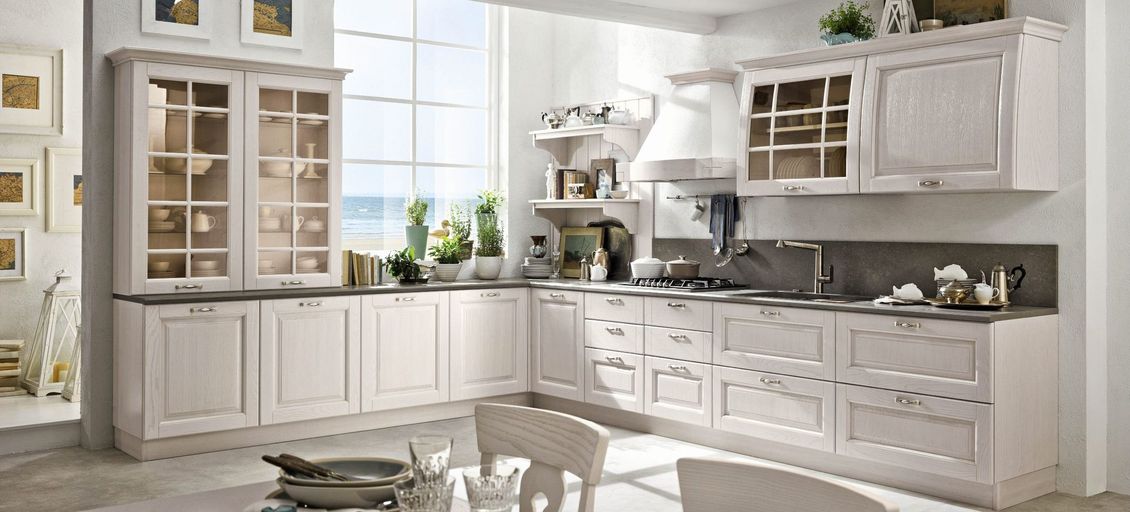 Una cucina con mobili bianchi e una grande finestra.
