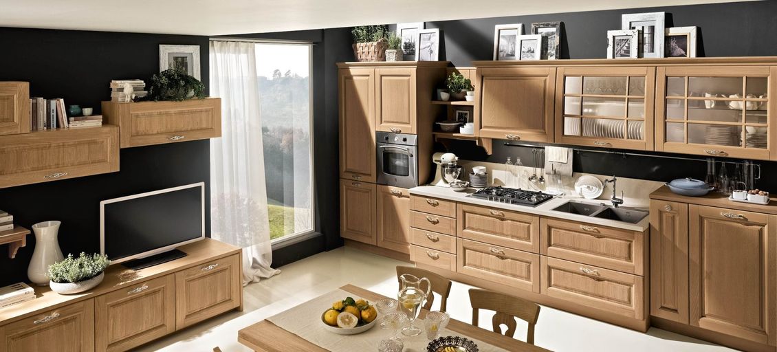 Una cucina con mobili in legno, tavolo e sedie