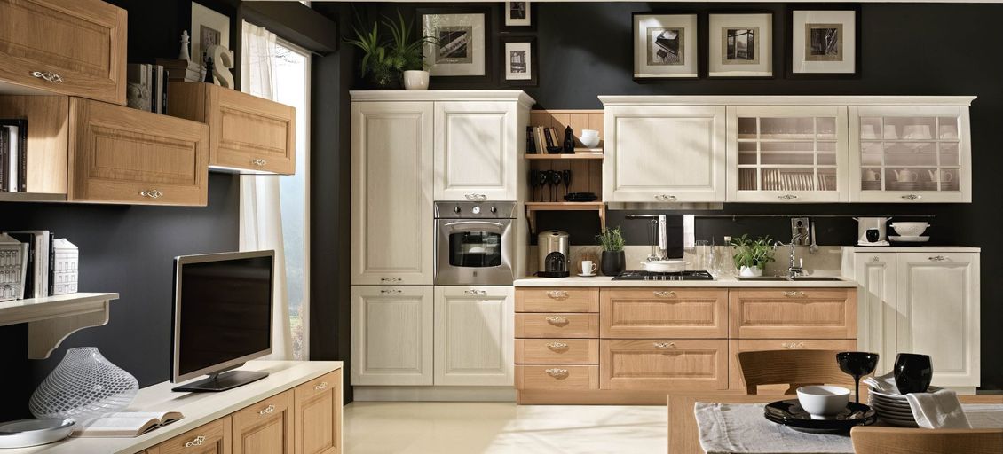 Una cucina con mobili in legno e tv a schermo piatto