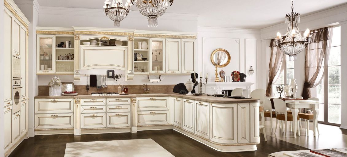 Una cucina con mobili bianchi e un lampadario appeso al soffitto.